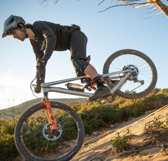 A biker descends a steep mountain on his mountain bike.