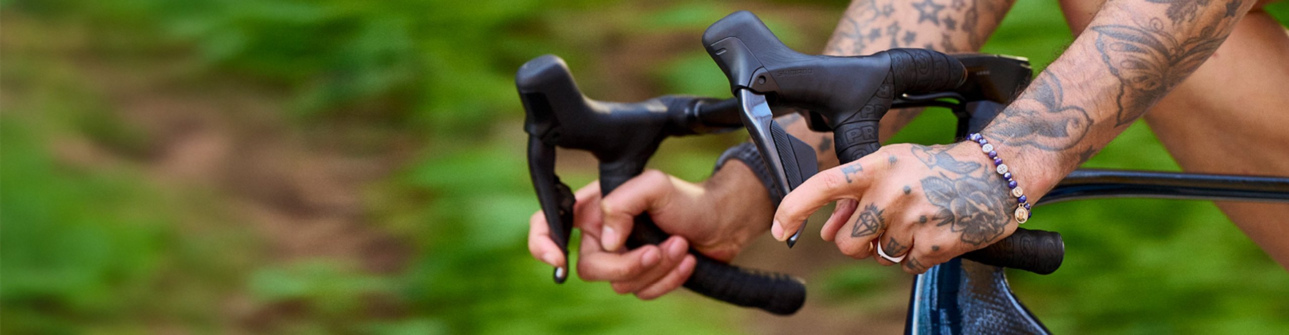 Cycliste sur route tenant un cintre avec ruban de cintre PRO lors d’une sortie en pleine verdure.