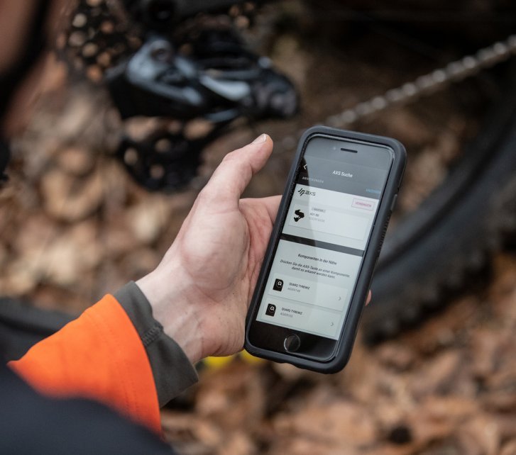 A cyclist configures his SRAM AXS shifting system with the help of his smartphone.