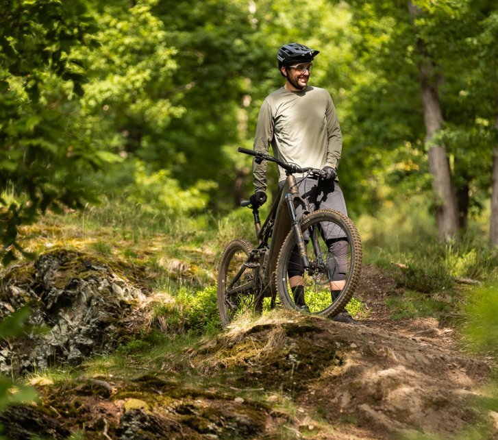 Berno steht mit dem Turbo Levo 4 im Wald und sieht aus, als wäre er glücklich. 