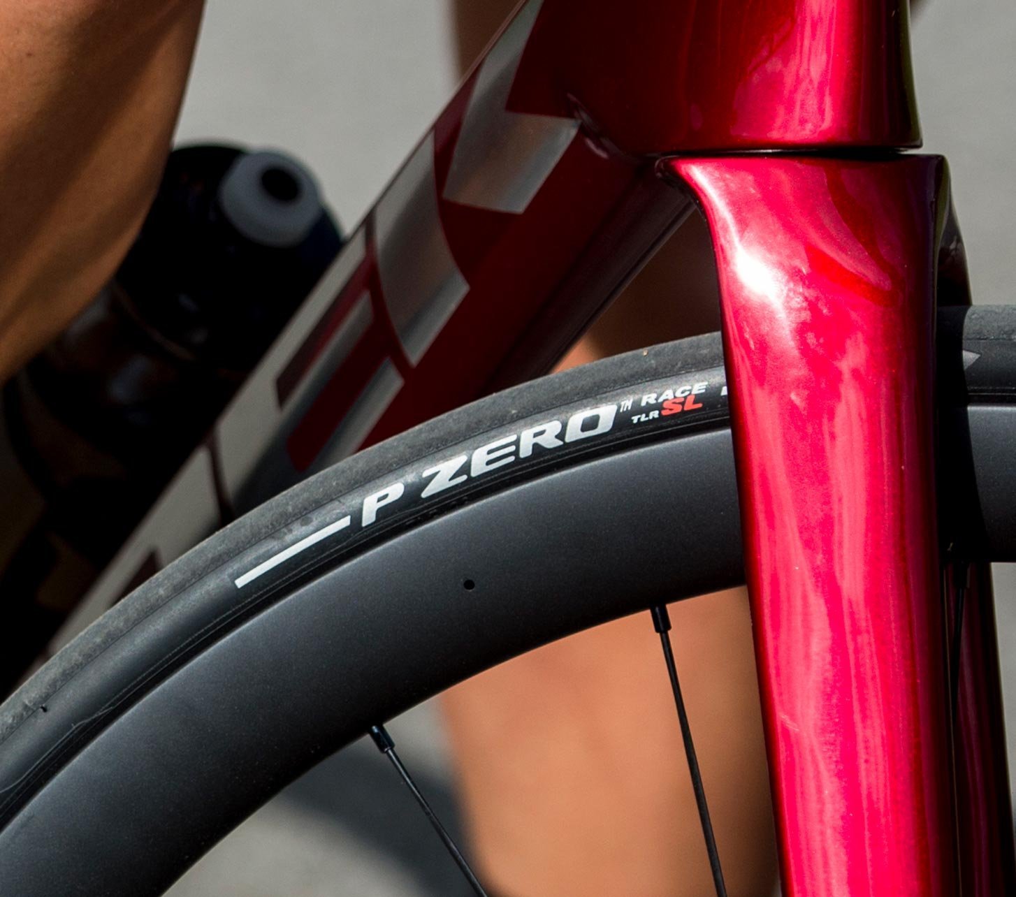 Neumático de carretera Pirelli P ZERO Race en la rueda delantera de una bicicleta roja en marcha deportiva.