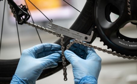 Utilizando un medidor de desgaste de cadenas, Thomas mantiene la cadena bajo tensión mientras determina la longitud óptima de la cadena. 