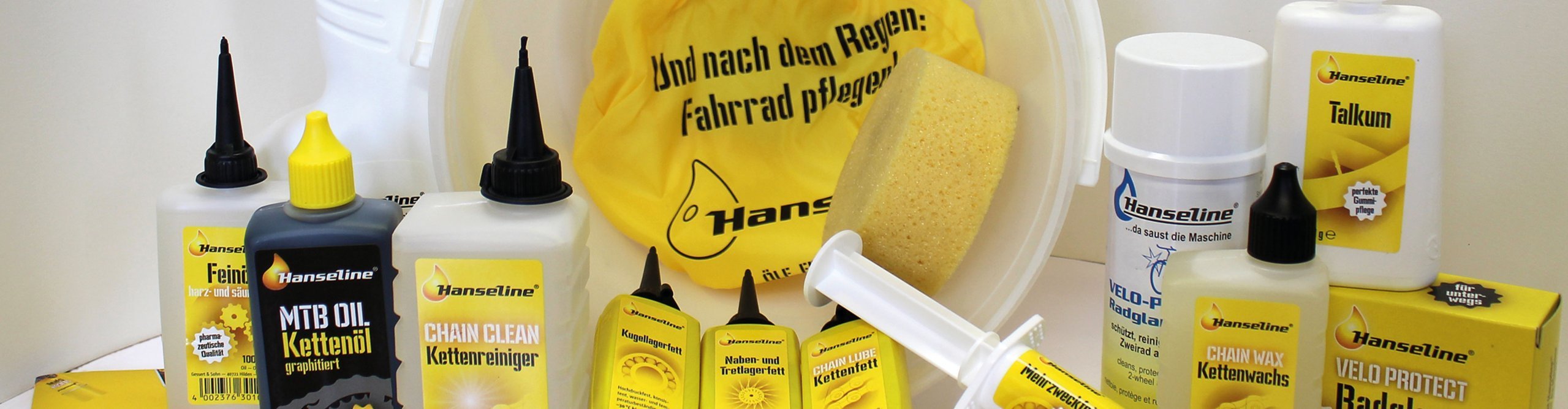 Produits d’entretien vélo Hanseline avec huile, nettoyant et cire pour chaîne, graisse pour roulements et accessoires de nettoyage.