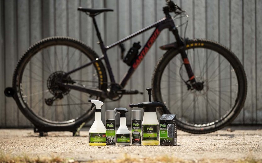 Produkte zur Reinigung und Pflege eines Fahrrads stehen zur Säuberung eines Mountainbikes bereit. 