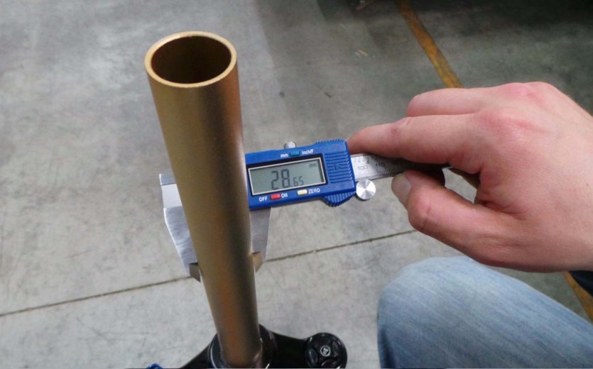 Mit einem Messschieber wird der Durchmesser eines Gabelschafts gemessen.