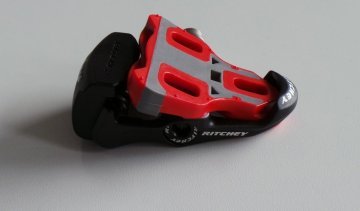 Ein Rennrad Klickpedal und das dazugehörige Cleat