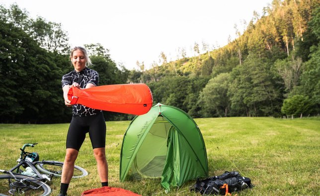 Svenja tomando el aire necesario con su saco de bombeo para inflar la colchoneta aislante.