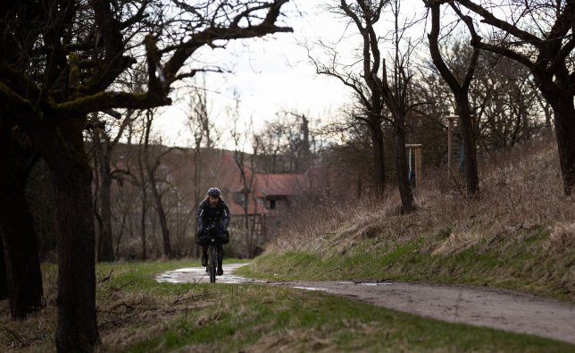 Christian unterwegs über einen matschigen Feldweg. Es hat kurz zuvor geregnet und die Dämmerung bricht an.