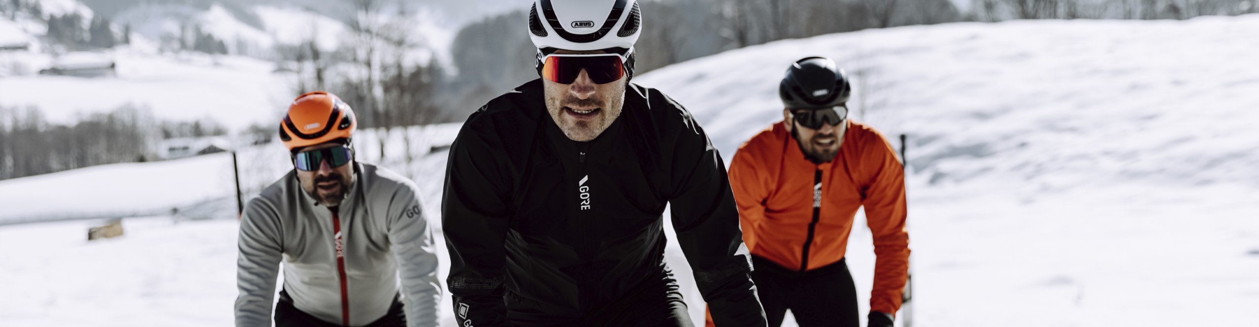 Drei Rennradfahrer fahren durch den Schnee