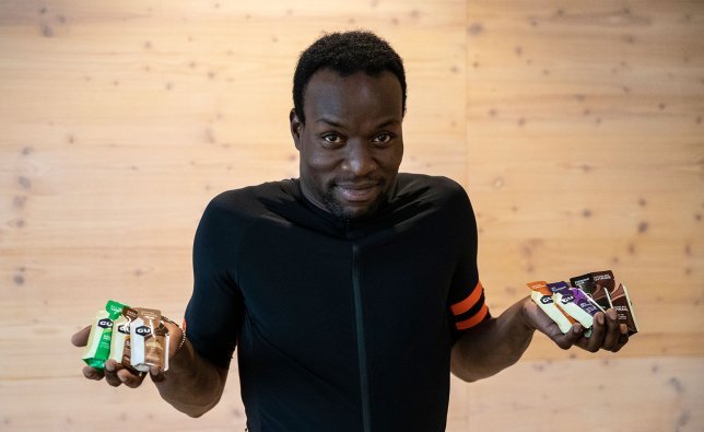 Un homme tient différents gels énergétiques devant la caméra.