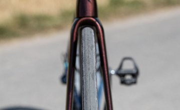 La photo montre la roue avant d'un Specialized Tarmac. Le cadrage montre le vélo de face, de sorte que toute la largeur du pneu est visible.