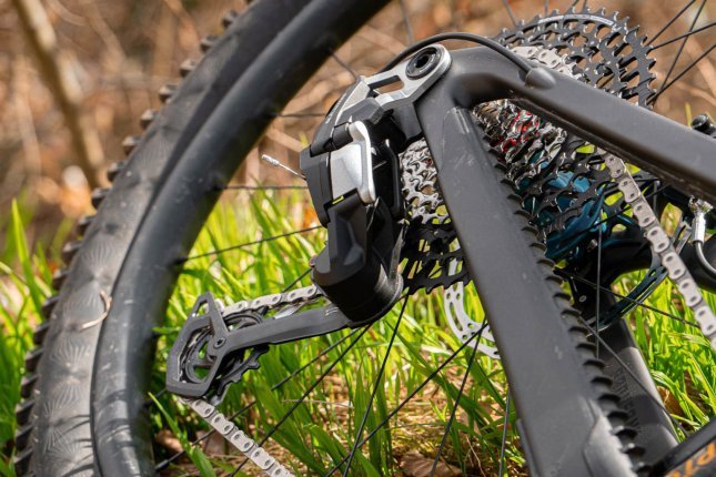 Foto de detalle: Un desviador SRAM Transmission en una bicicleta gris asfalto