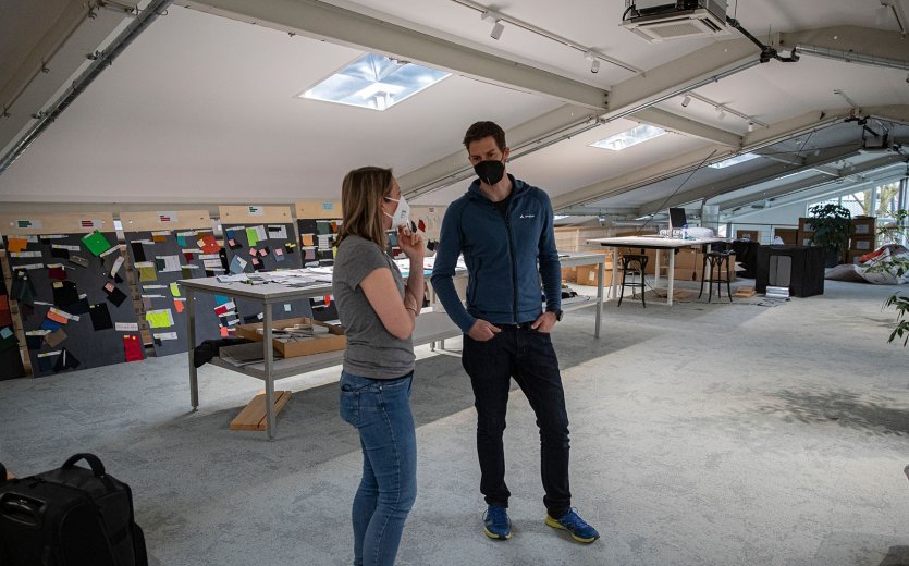 bc-Brandmanagerin Svenja und Vaude-Produktmanager Markus im Gespräch auf einer lichtdurchfluteten Galerie.
