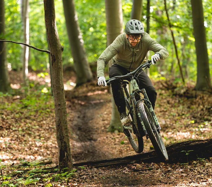 bc-Tester Berno springt mit dem Specialized Turbo Levo R über einen Baumstamm