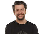 Portrait von bc-Autor Berno in einem schwarzen T-Shirt. Berno ist ca. 45 Jahre alt, trägt dunkles, mitellanges, gewelltes Haar und einen Vollbart und lacht in die KAmera.