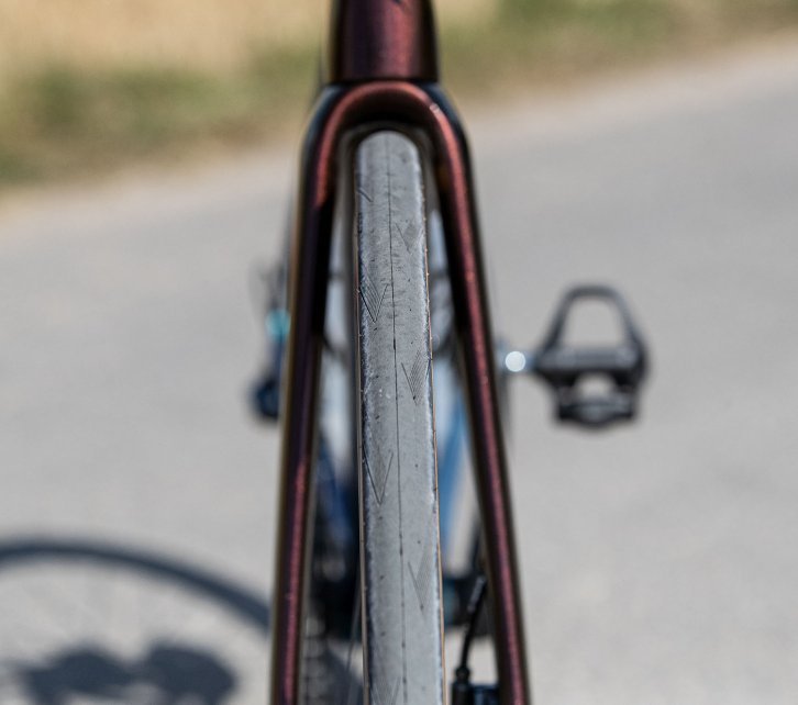 La photo montre la roue avant d'un Specialized Tarmac. Le cadrage montre le vélo de face, de sorte que toute la largeur du pneu est visible.