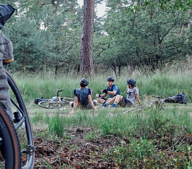 3 Gravelfreunde machen eine Pause im Wald