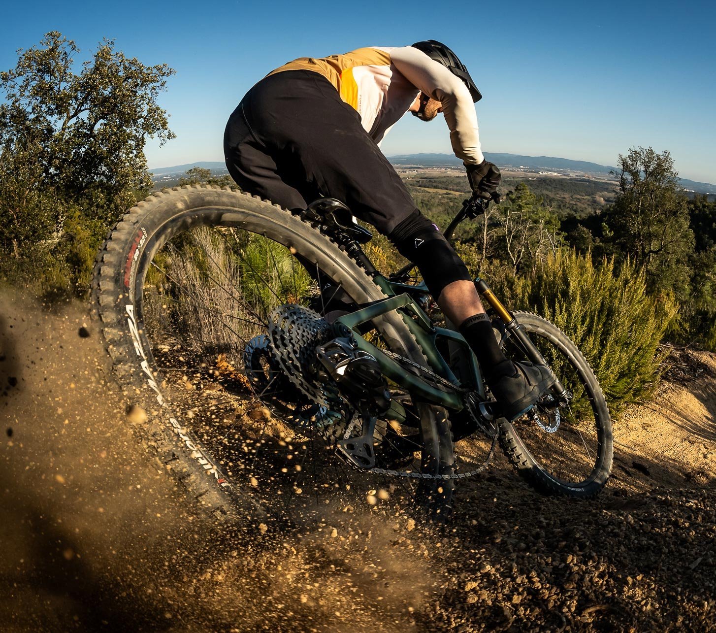 Shimano MTB Bremsen im Einsatz: Mountainbiker fährt eine staubige Kurve auf anspruchsvollem Trail