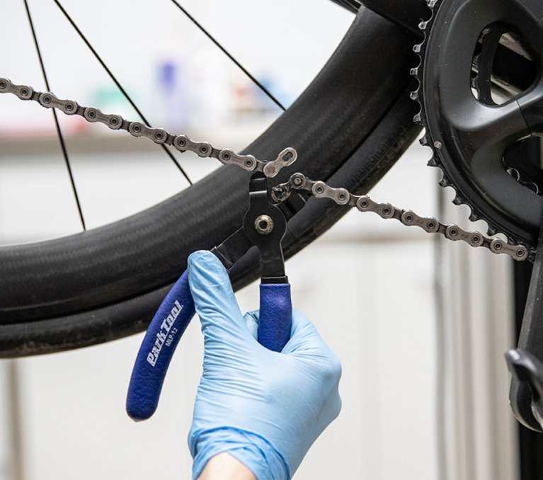 bc Mechanic Thomas opens the master link on a road bike chain.