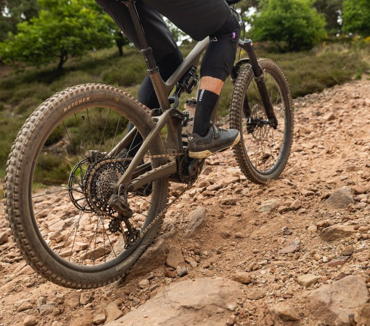 Detailfoto: Ein Turbo Levo 4 fäht bergauf über einen geschotterten Trail. 