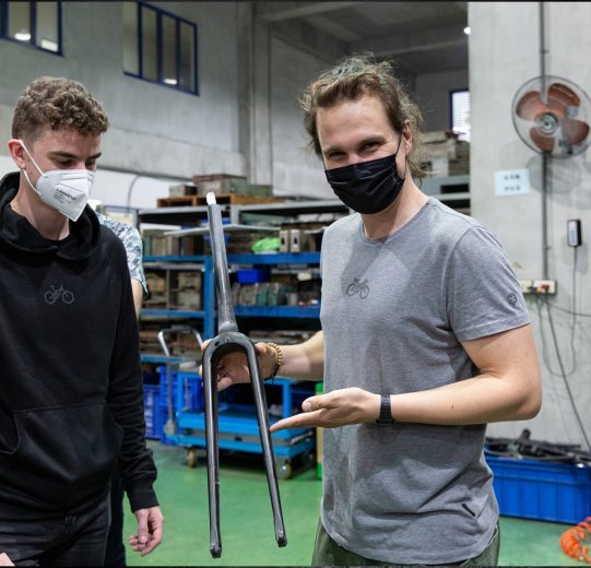 bc Produktmanager Ludwig und Christoph halten die bc original Kol Gabel in der Fabrik in der Hand. 