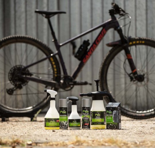 Produkte zur Reinigung und Pflege eines Fahrrads stehen zur Säuberung eines Mountainbikes bereit.