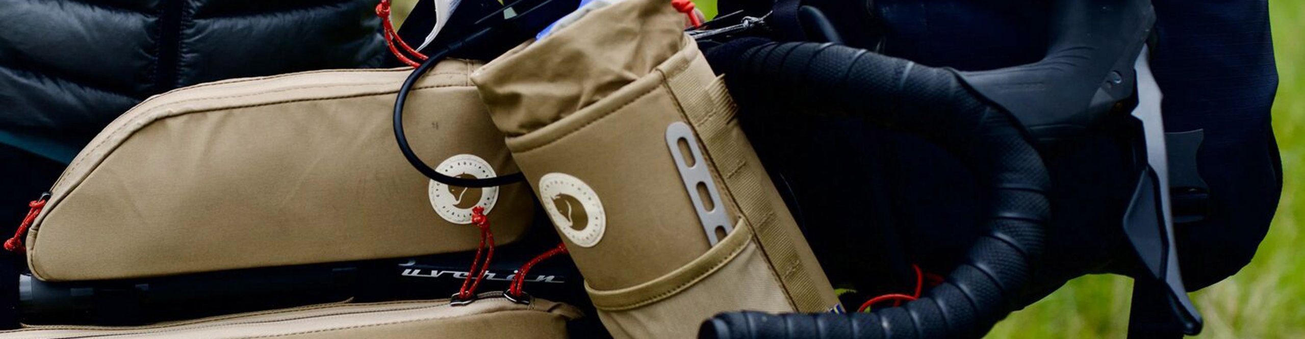 Équipement de bikepacking avec sacoches vélo Fjällräven jaunes sur le cintre et le tube supérieur d’un gravel Specialized