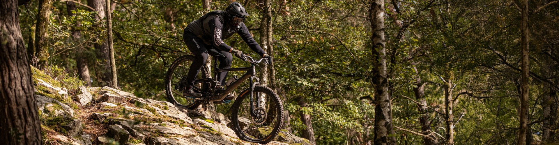 Ein Biker auf einem MTB fährt über einen Felsen