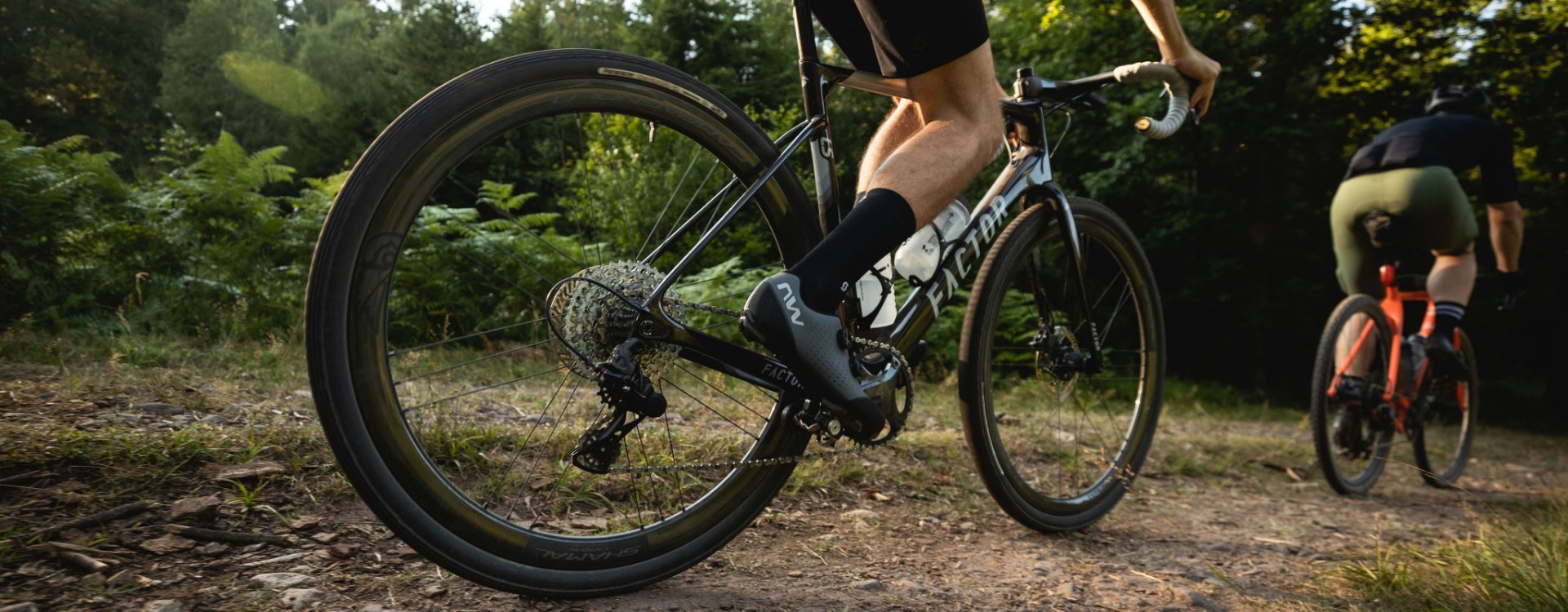 Chris et Björn de l'équipe de bc sont en route avec leurs vélos de gravel. La photo se concentre sur le Factor LS de Chris. 