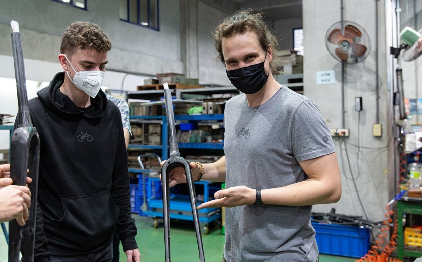 Ludwig et Christoph, chefs de produit chez bc, tiennent la fourche bc original Kol en main dans l'usine. 