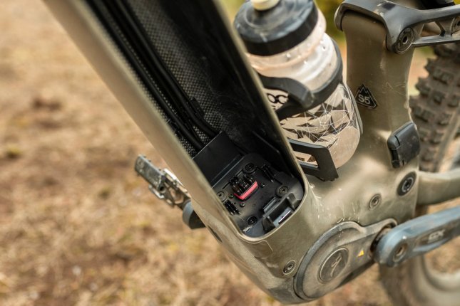 Detailfoto: Blick ins leere Unterrohr eines Turbo Levo 4 E-MTB: Der Akku wurde entnommen, man sieht das Carbongewebe und die Kontakte zum Motorsystem