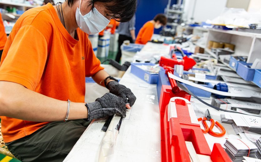 A production worker lays the fork from several carbon blanks.