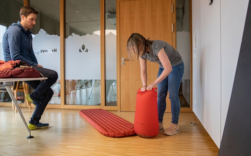 bc-Brandmanagerin Svenja befüllt eine Isomatte mit Hilfe eines Pumpsacks.