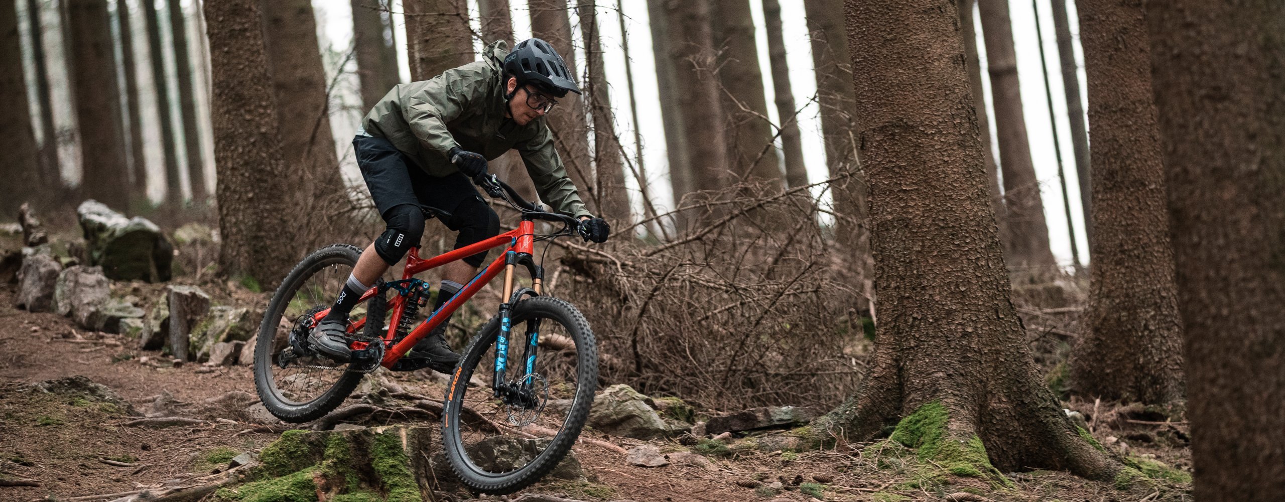 Mountainbiker fährt Trail im Wald in Winterbekleidung