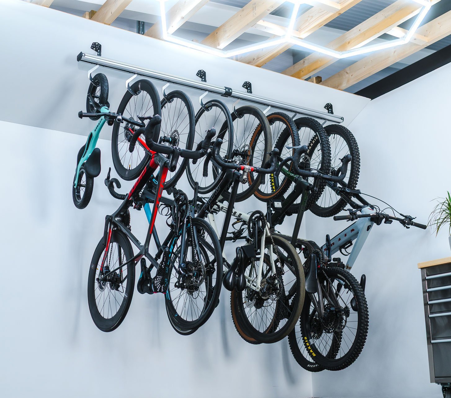 Stashed Fahrradaufhängung mit mehreren platzsparend nebeneinander aufgehängten Rennrädern, Gravelbikes und Mountainbikes.