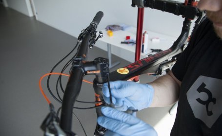 Our mechanic loosens a bolt on the stem of a mountain bike to be able to detach the stem from the steerer tube.