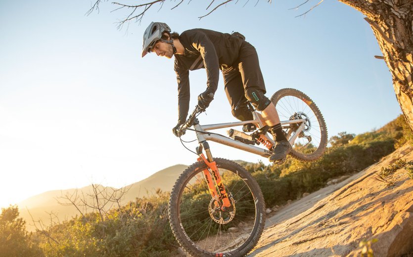 Christian de l'équipe de gestion des produits de bc fait un stoppie sur un rocher. Il conduit un VTT RAAW Madonna.