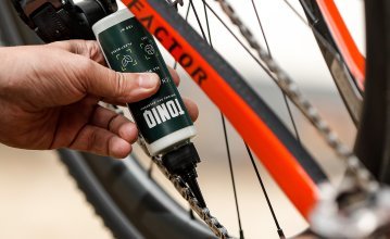A bike chain is greased with TONIQ Chain Wax.