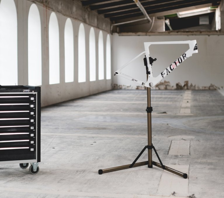 Carro de herramientas y soporte de montaje en una nave industrial vacía con grandes ventanas.