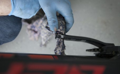 The pedal thread of a crankset is being cleaned.