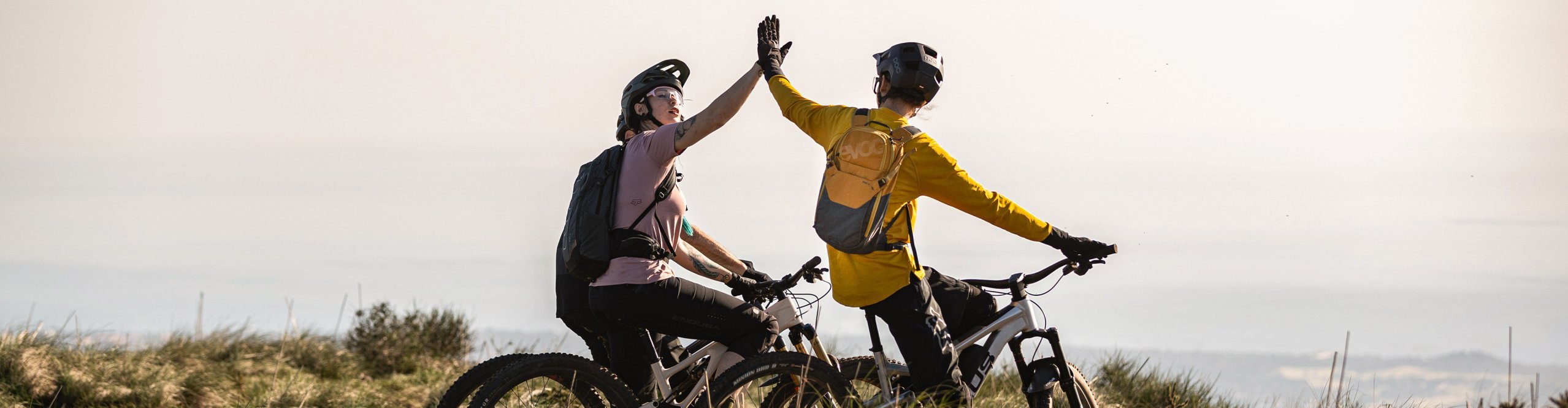 Mountainbiker mit evoc Rucksäcken geben sich Highfives