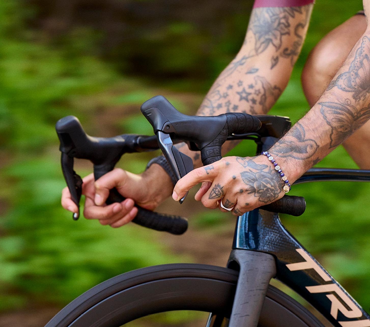Cycliste sur route tenant un cintre avec ruban de cintre PRO lors d’une sortie en pleine verdure.