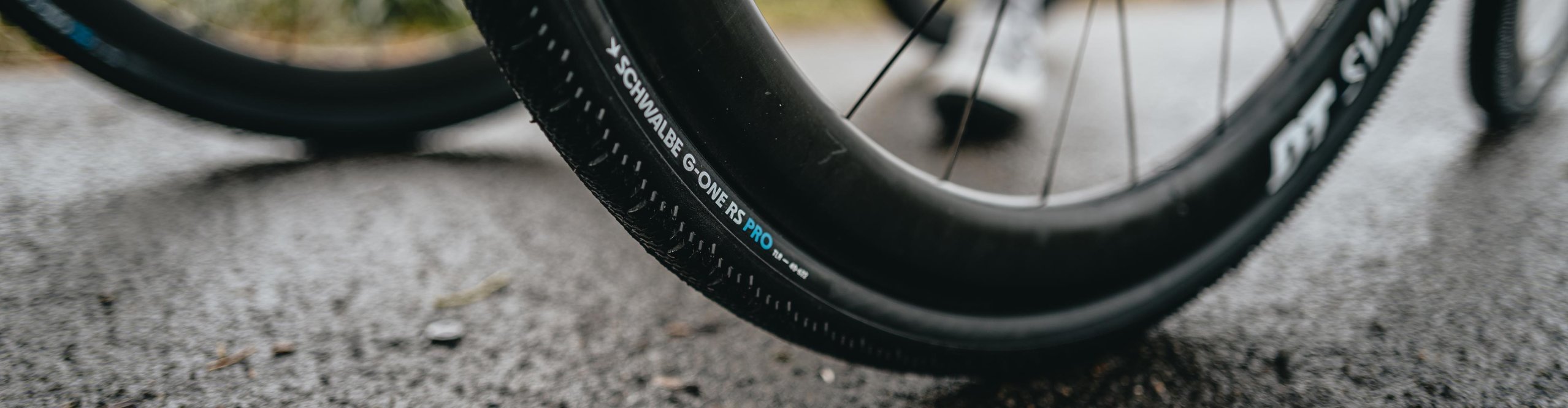 Nahaufnahme des Schwalbe G-One RS Pro Gravel-Reifens auf Carbon-Laufrad im Einsatz auf Asphalt – schneller Tubeless Gravelbike-Reifen für Race, Grip und Kontrolle