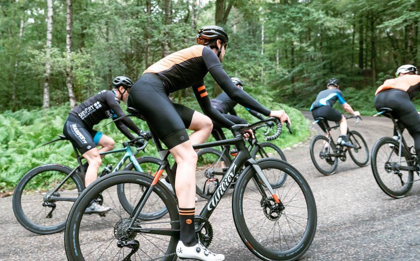 A group of road cyclists is riding into a climb. All bikes are equipped with Shimano Dura-Ace Di2 groupsets.