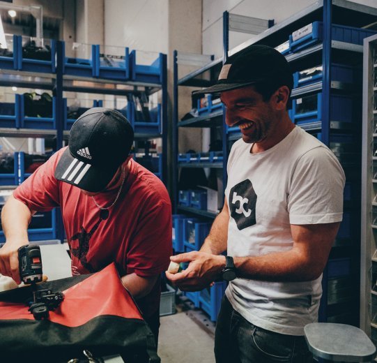 Andi looks over the shoulder of one of the employees while repairing a pannier.