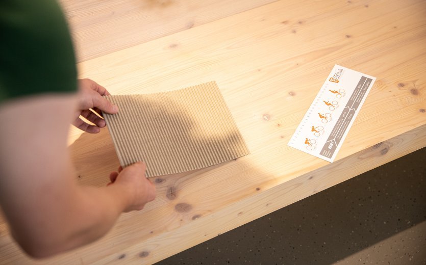 Coloca el cartón de medición sobre una superficie firme y recta, preferiblemente en una silla de madera sin asiento curvo.