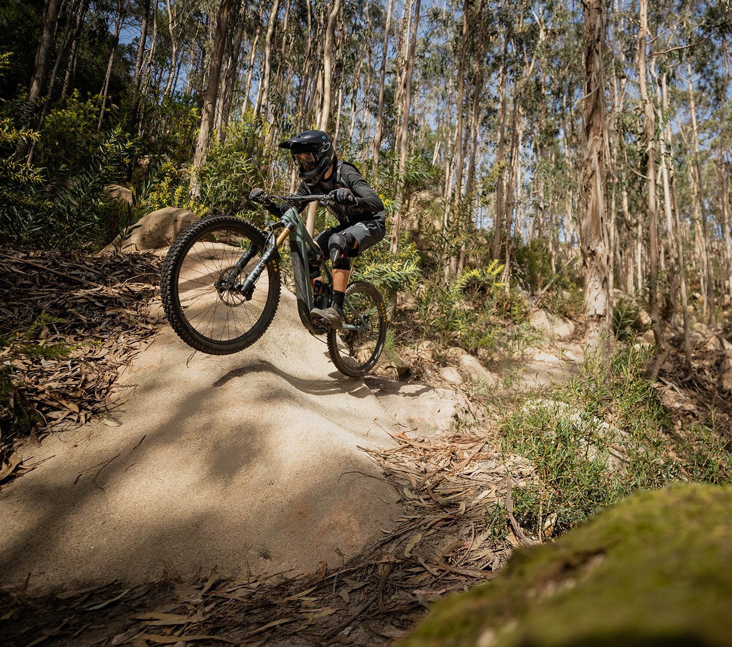 E-Mountainbike Fahrer springt über Hügel