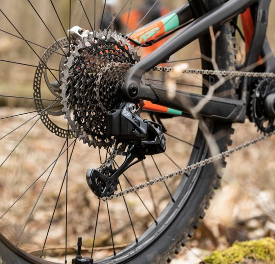 Pictured is a Santa Cruz full-suspension bike equipped with an electronic SRAM X01 EAGLE AXS in the forest.