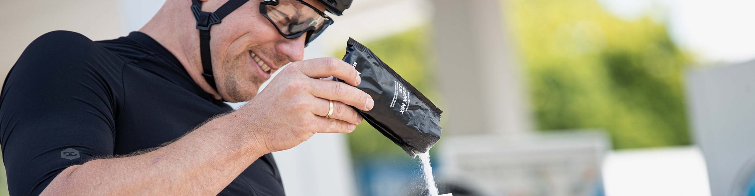 Radfahrer füllt seine Trinkflasche mit Elektrolytpulver auf.