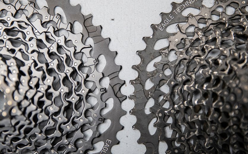 This image compares two SRAM cassettes. A new one is on the left, while an older one with clear signs of wear is on the right. 